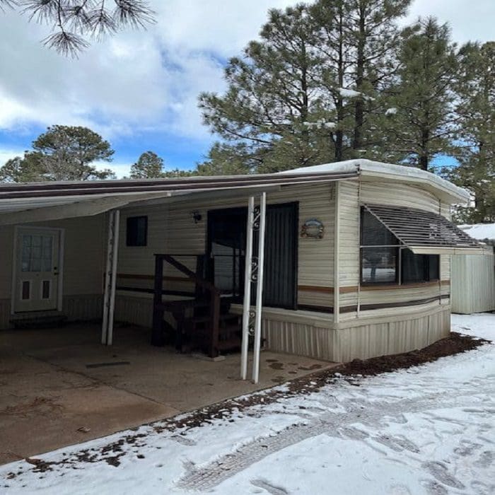 A mobile home with snow on the ground.